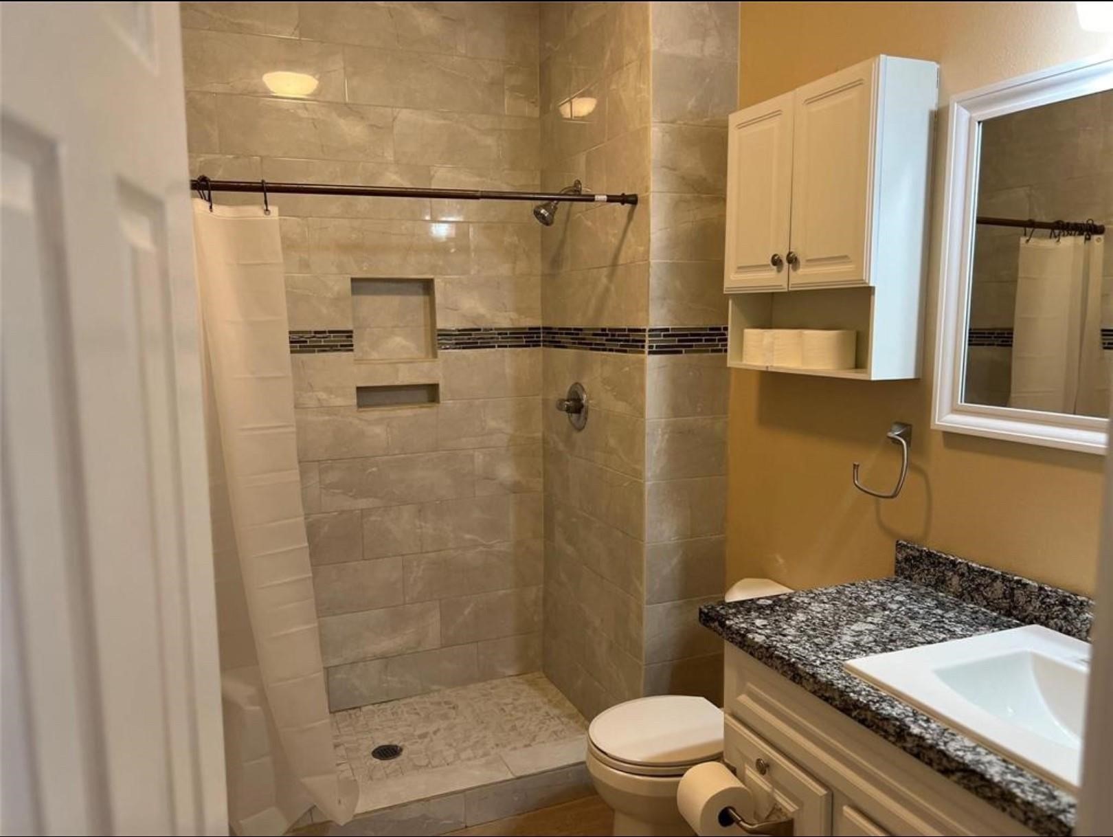4733 16th Street Bacliff, TX 77518 - Photo 11 of 11 a bathroom with a sink a toilet a mirror and shower
