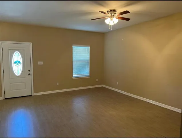an empty room with a window and a ceiling fan