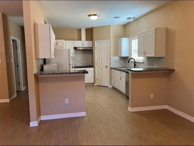 a kitchen with stainless steel appliances granite countertop a sink a stove and a refrigerator