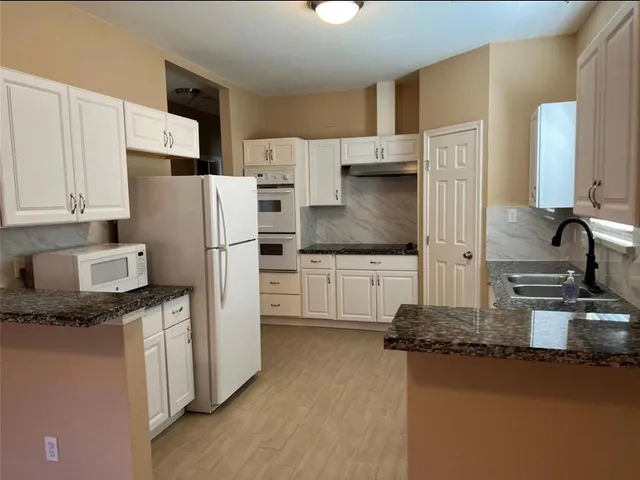 a kitchen with stainless steel appliances a refrigerator sink and stove