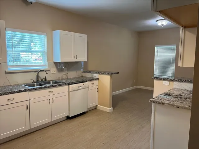 a kitchen with granite countertop a sink and a stove