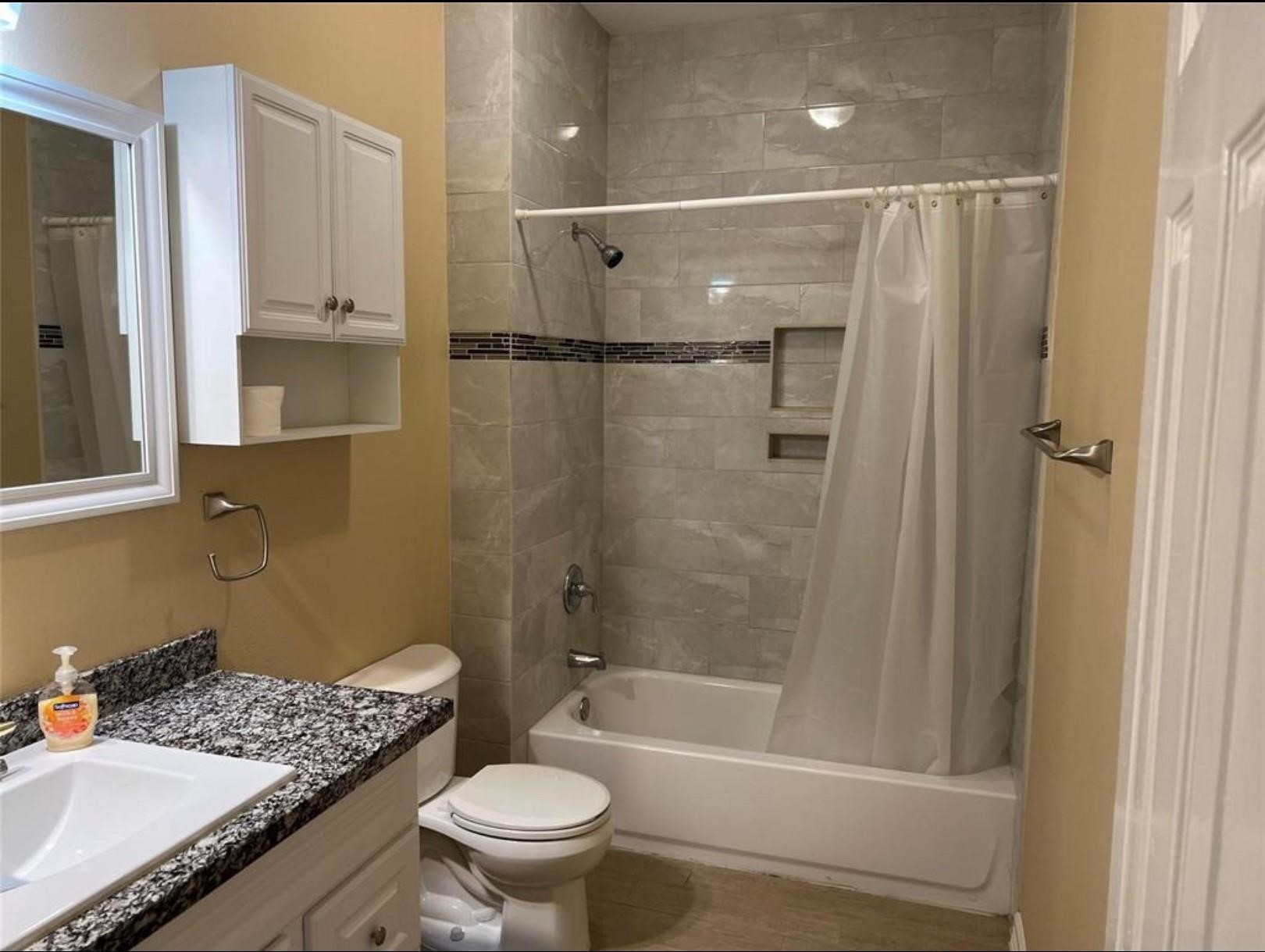 4733 16th Street Bacliff, TX 77518 - Photo 8 of 11 a bathroom with a granite countertop sink toilet and shower