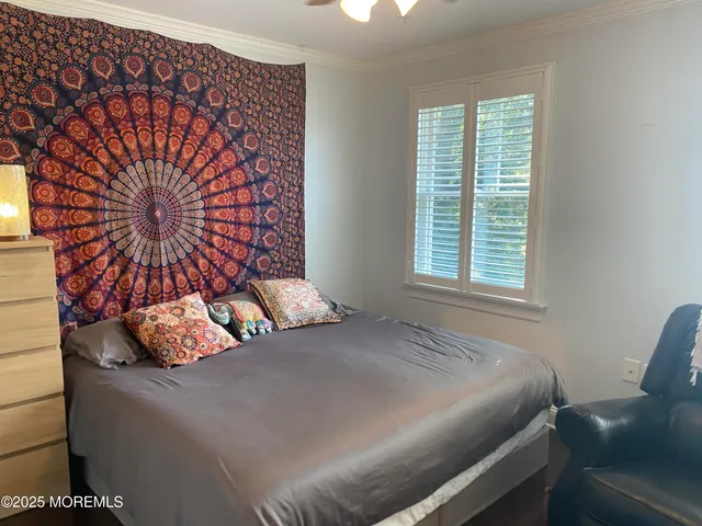 a bedroom with a bed and next to a window