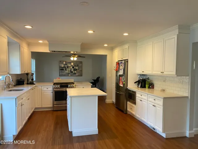 a kitchen with white cabinets and stainless steel appliances
