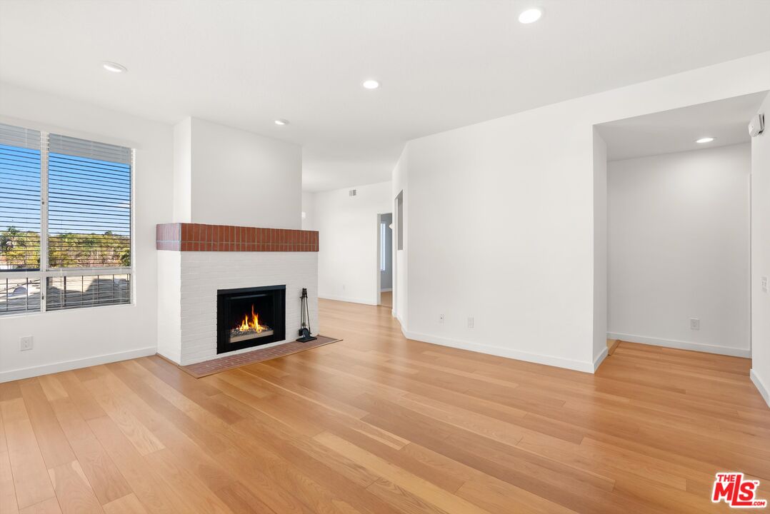 4643 East 4th Street, Unit 22 Long Beach, CA 90814 - Photo 6 of 40 a view of an empty room with wooden floor fireplace and a window