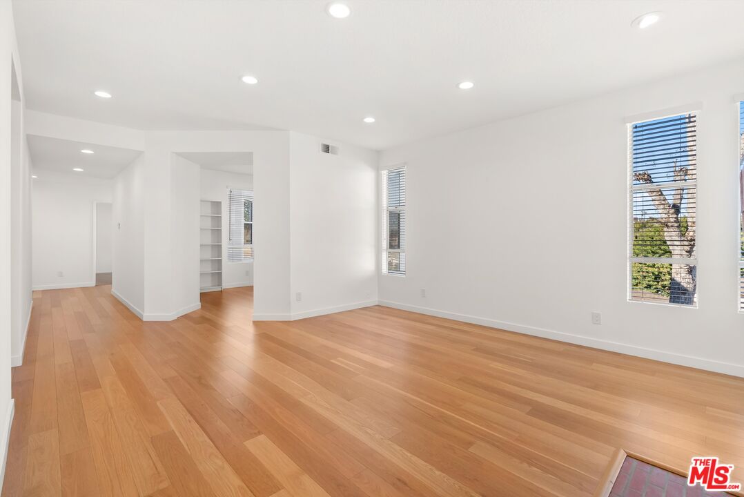 4643 East 4th Street, Unit 22 Long Beach, CA 90814 - Photo 8 of 40 a view of an empty room with wooden floor and a window