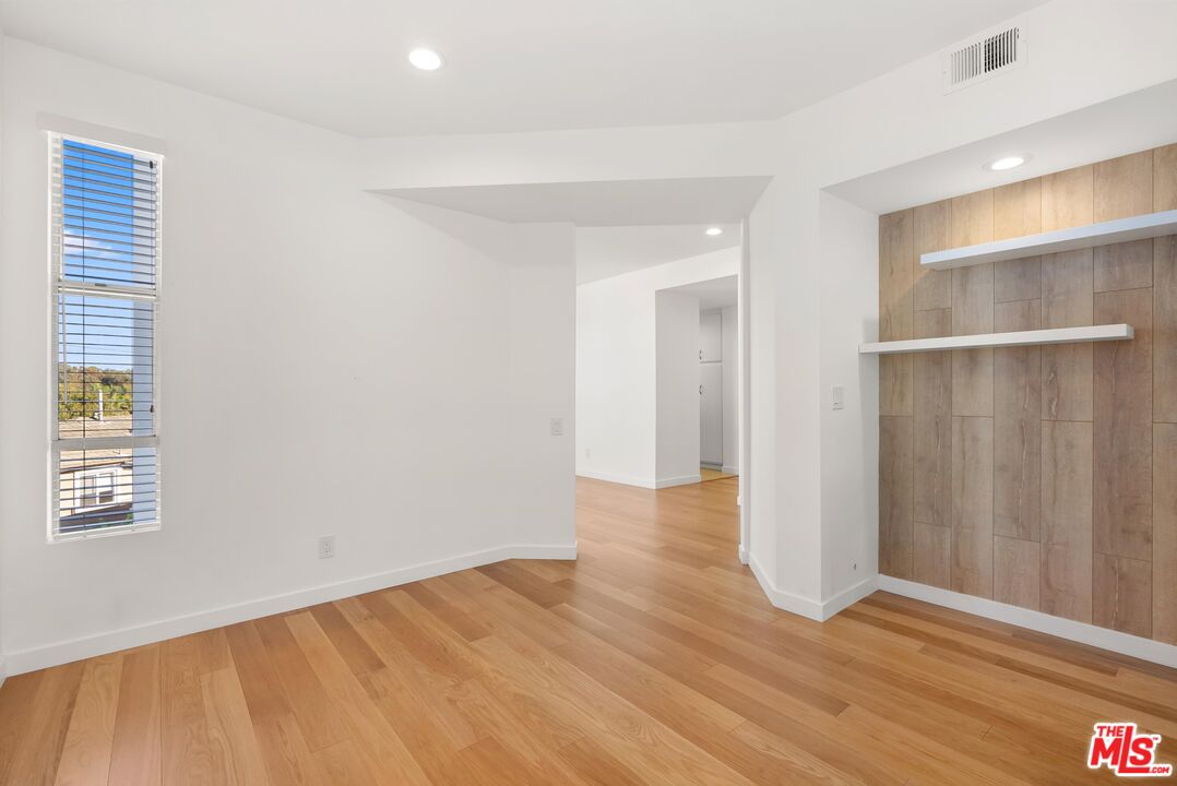 4643 East 4th Street, Unit 22 Long Beach, CA 90814 - Photo 10 of 40 a view of an empty room with wooden floor and a window