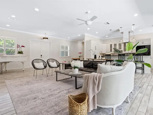 a kitchen with stainless steel appliances granite countertop a stove top oven a sink dishwasher a dining table and chairs with wooden floor