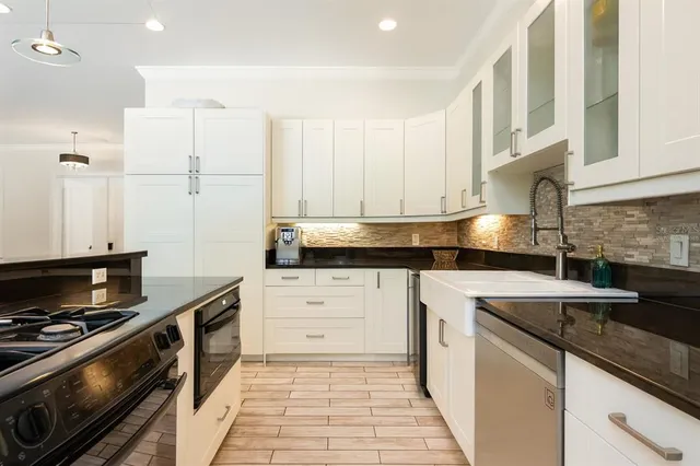 a kitchen with stainless steel appliances granite countertop a stove and a sink