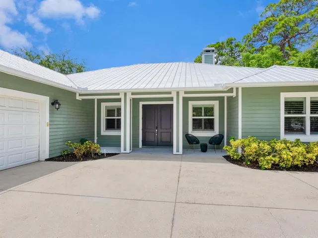 a view of a chair and table in back of the house