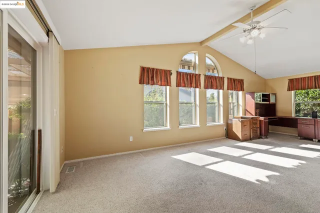 a view of an empty room with a fireplace and a window
