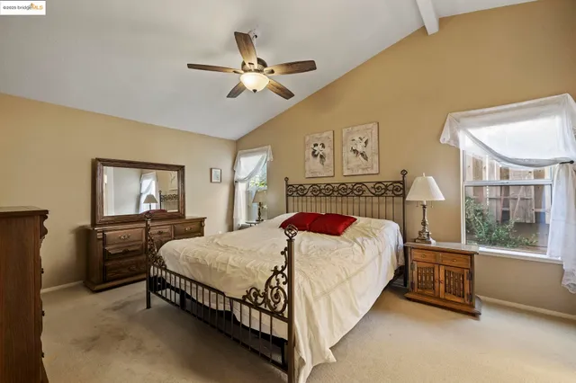a bedroom with a bed a dresser next to a window