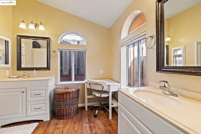 a spacious bathroom with a double vanity sink a mirror and a bathtub