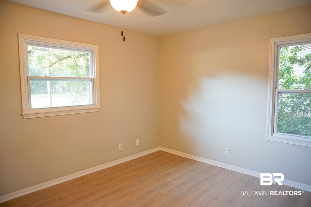 6205 Zeigler Boulevard Mobile, AL 36608 - Photo 9 of 17 Empty room featuring light wood finished floors, healthy amount of natural light, and ceiling fan
