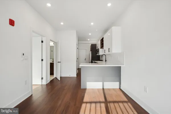 a kitchen with a sink stainless steel appliances a refrigerator and cabinets