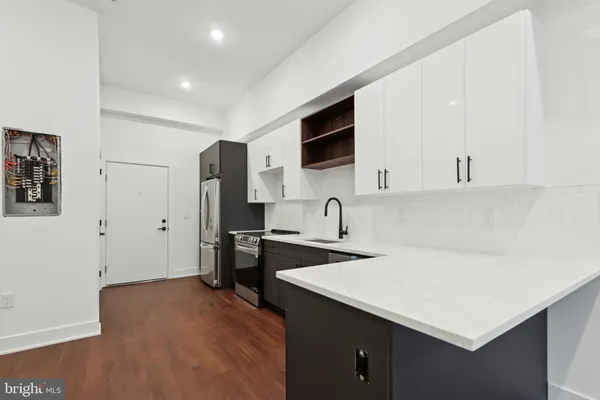 a kitchen with stainless steel appliances a sink a stove a refrigerator and cabinets