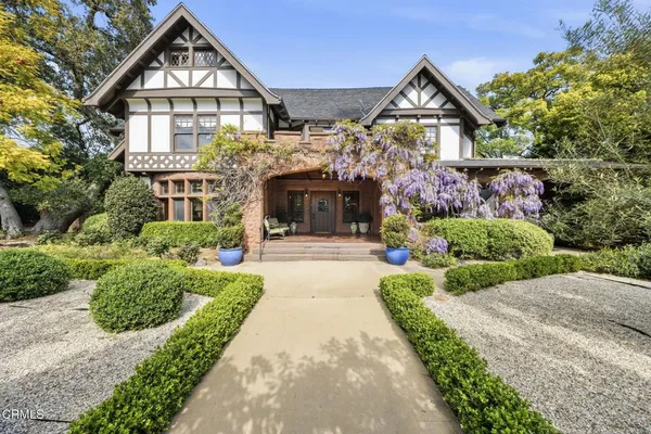 a front view of a house with a garden and plants