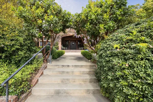 a view of a house with a yard and pathway