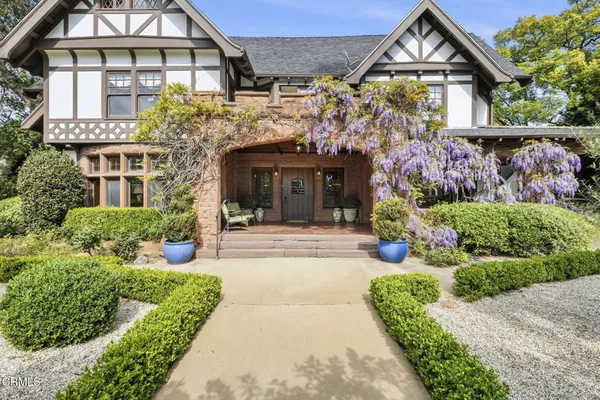 a view of a building with a yard and potted plants