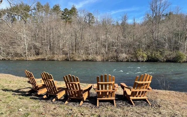 a view of a lake with lawn chairs