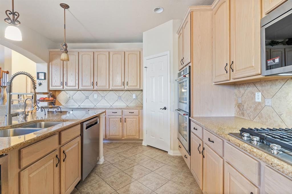 2228 Condor Street Grand Prairie, TX 75052 - Photo 15 of 33 a kitchen with stainless steel appliances granite countertop a stove a sink and a refrigerator