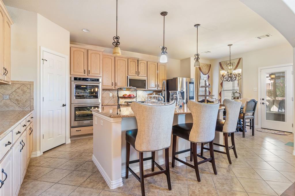 2228 Condor Street Grand Prairie, TX 75052 - Photo 18 of 33 a view of kitchen with stainless steel appliances kitchen island granite countertop dining table chairs and a view of living room