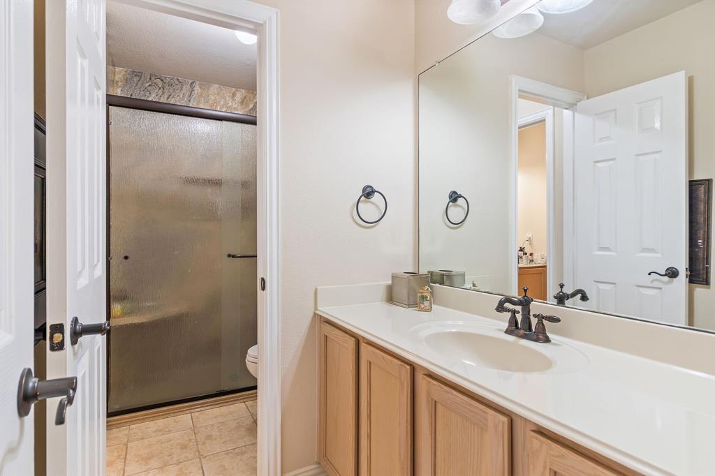2228 Condor Street Grand Prairie, TX 75052 - Photo 31 of 33 a bathroom with a double vanity sink mirror and shower