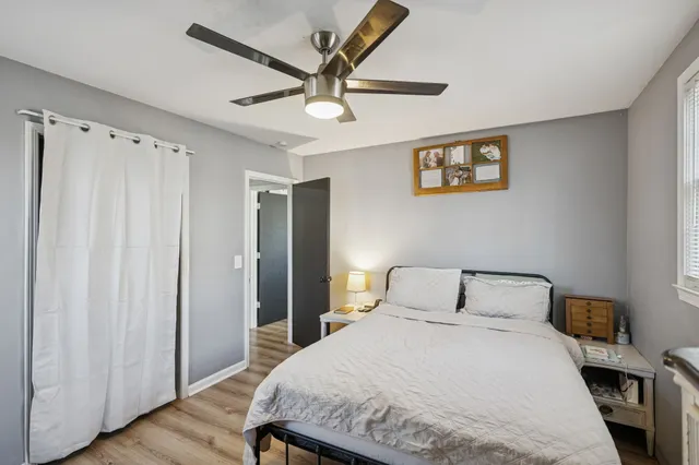 a bedroom with a large bed and wooden floor