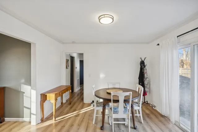 a living room with furniture kitchen island wooden floor and stainless steel appliances