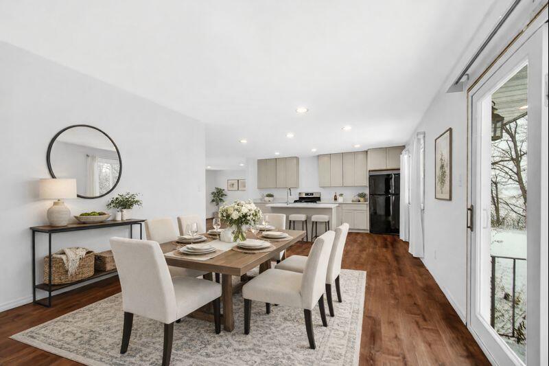 7210 East 97th Avenue Crown Point, IN 46307 - Photo 2 of 25 a view of a dining room with furniture and a wooden floor