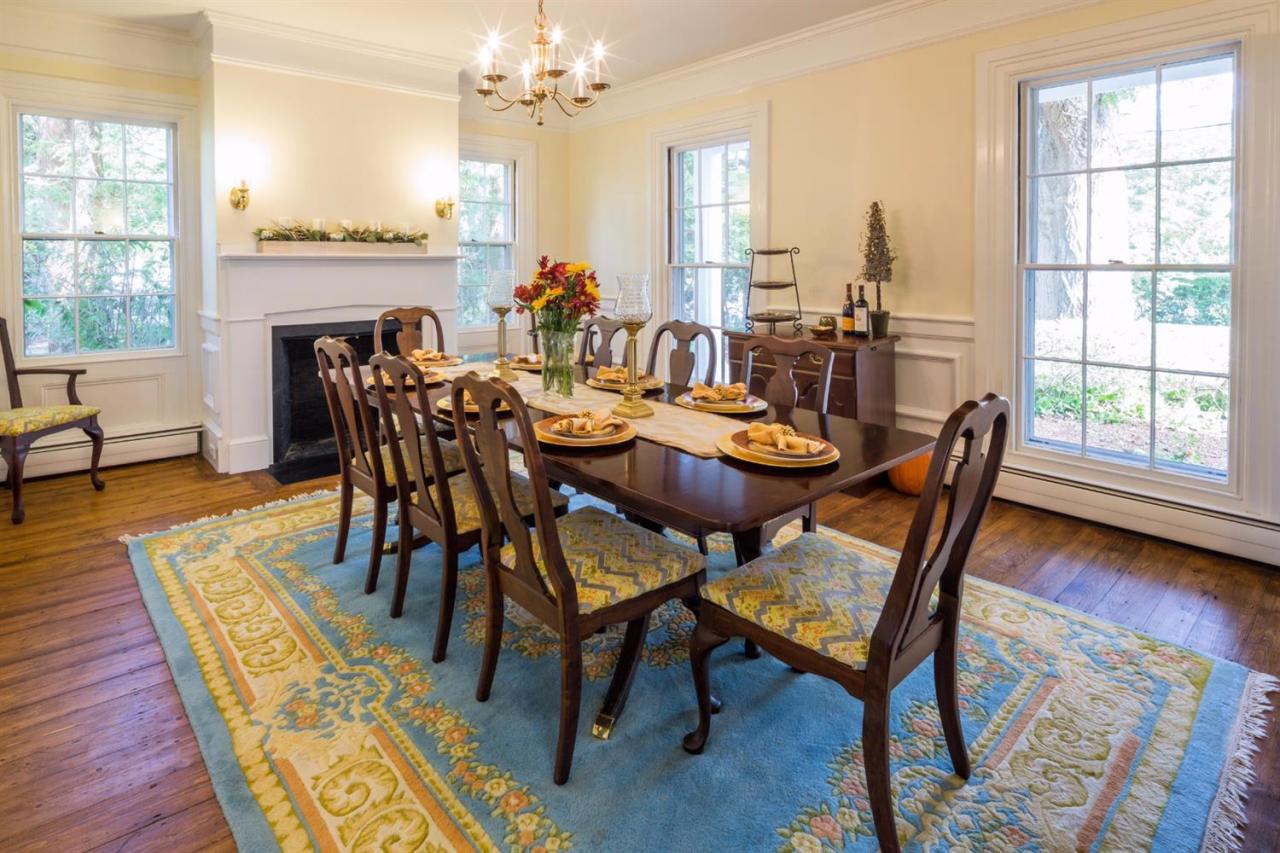 490 Main Street Centerville, MA 02632 - Photo 10 of 35 a dining room with furniture a rug a fireplace and a chandelier