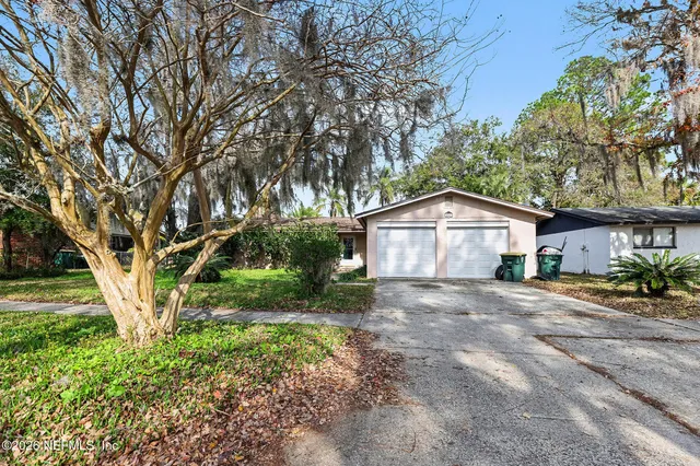 a front view of a house with a yard and trees
