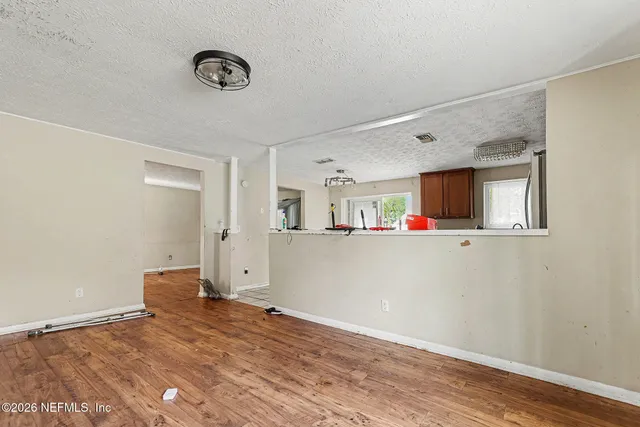 a view of empty room with wooden floor