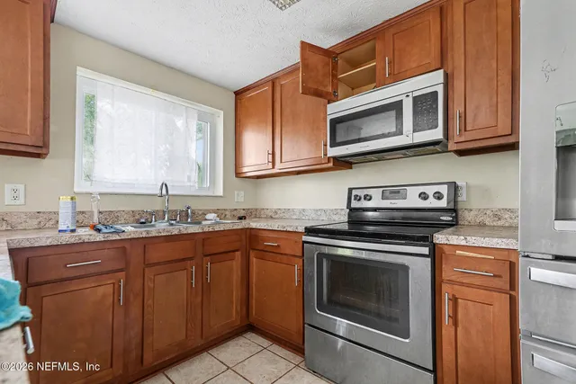 a kitchen with granite countertop a stove top oven microwave and cabinets
