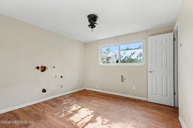 a view of empty room with wooden floor