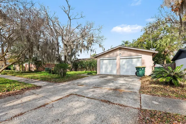 a view of a house with a yard and large tree