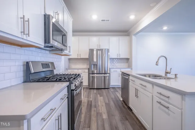 a kitchen with stainless steel appliances granite countertop a sink stove and refrigerator
