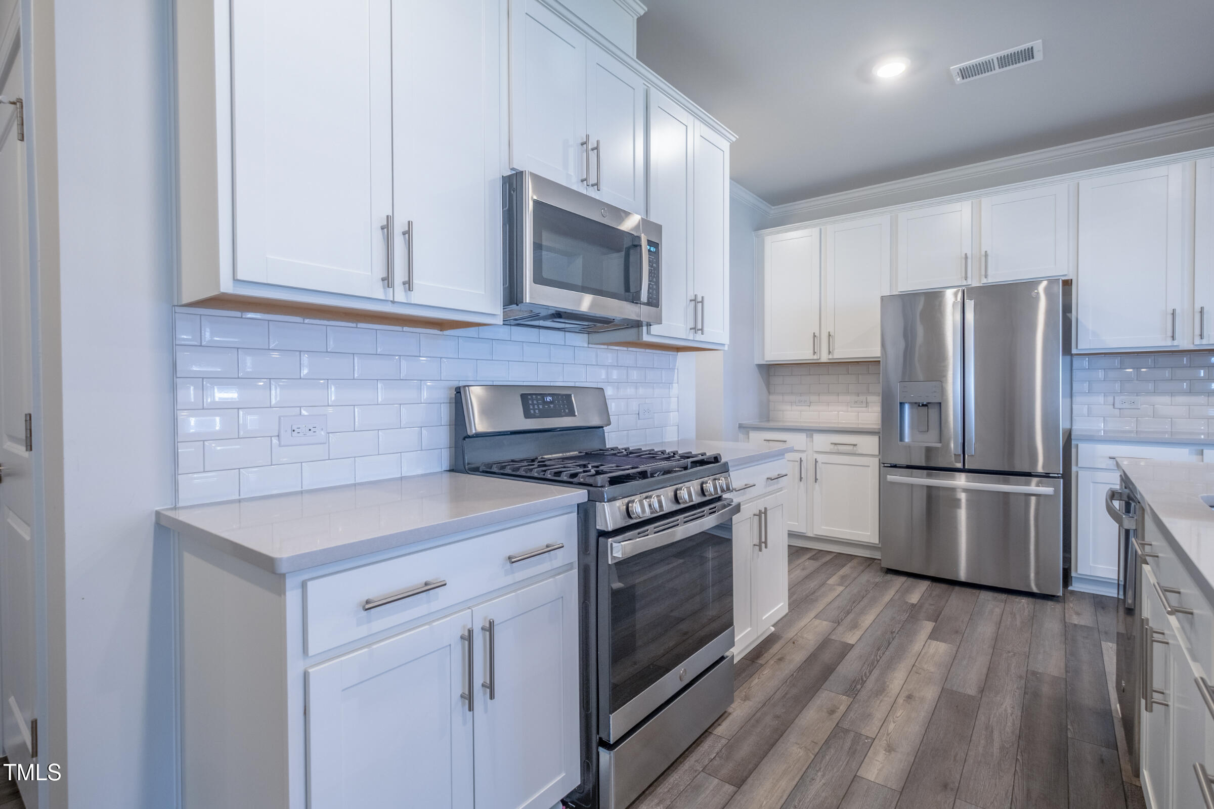 1726 Barrett Run Trail Apex, NC 27502 - Photo 20 of 50 a kitchen with white cabinets stainless steel appliances and wooden floor