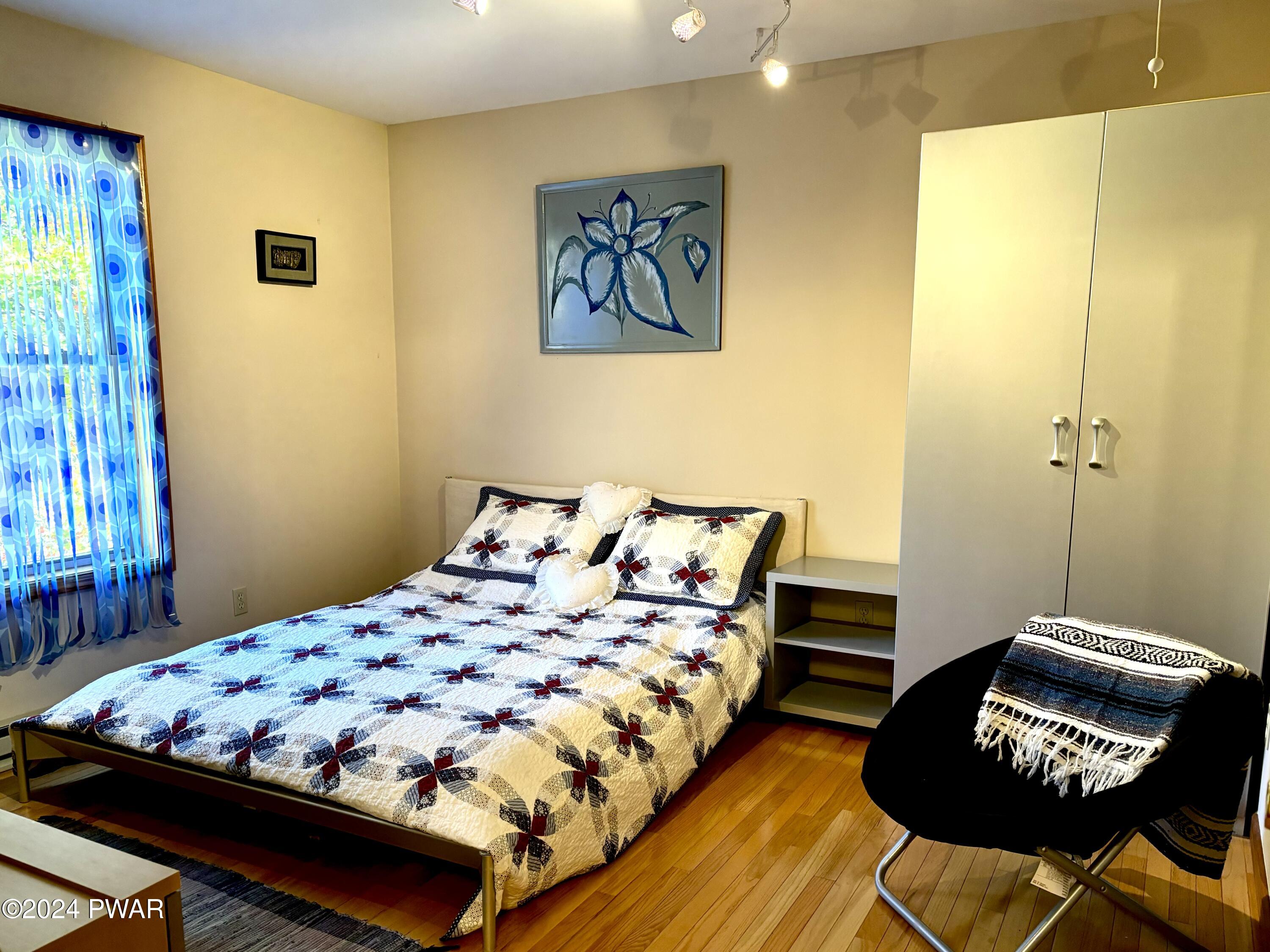 136 Stamford Road Dingmans Ferry, PA 18328 - Photo 22 of 52 a bedroom with a bed and chair