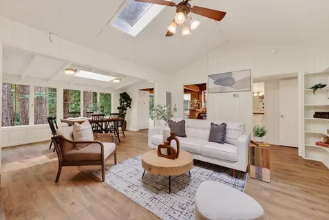 a living room with furniture and a floor to ceiling window