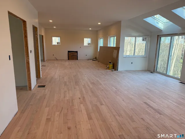 a view of a livingroom with wooden floor and furniture