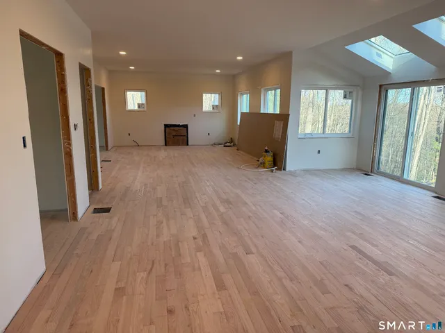 a view of a livingroom with wooden floor and furniture