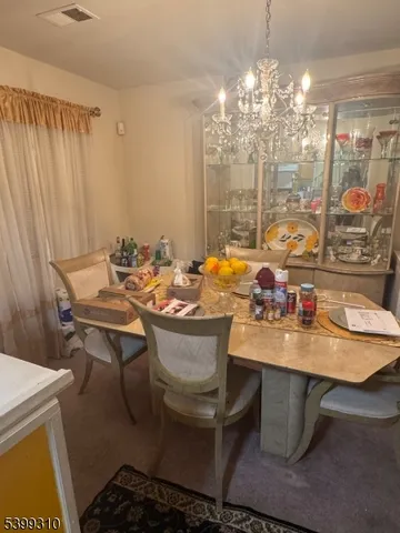 a room with a table chairs and a chandelier