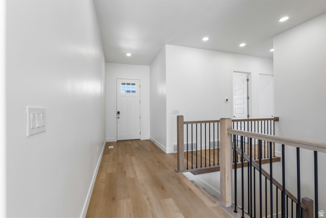 43 South Crimson Way, Unit 311 Mapleton, UT 84664 - Photo 7 of 28 Upper-level hallway featuring wood-finish flooring, recessed lighting, and a contemporary stair railing with black balusters and natural wood-tone handrails