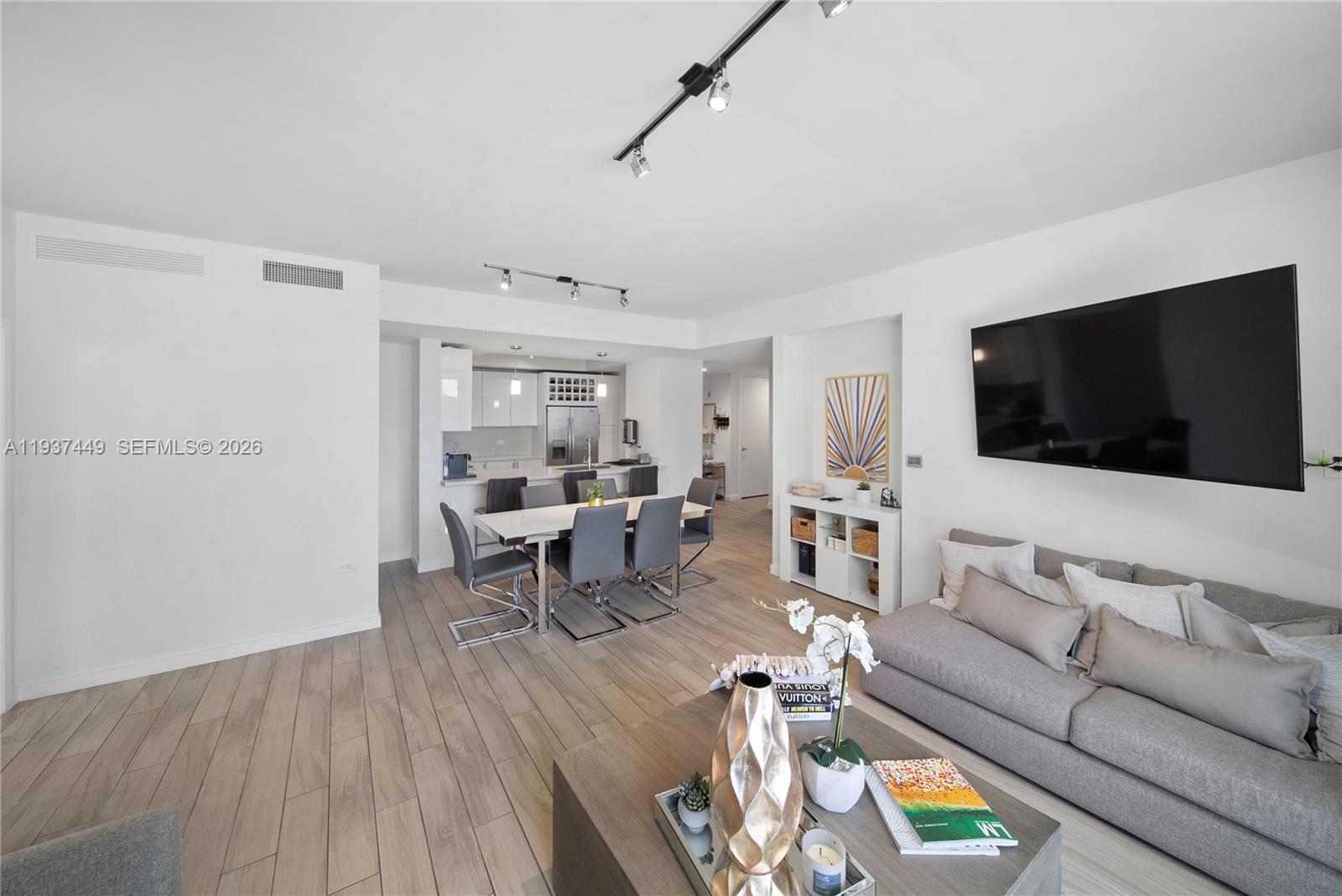 999 Southwest 1st Avenue, Unit 1617 Miami, FL 33130 - Photo 1 of 12 a living room with furniture and a flat screen tv
