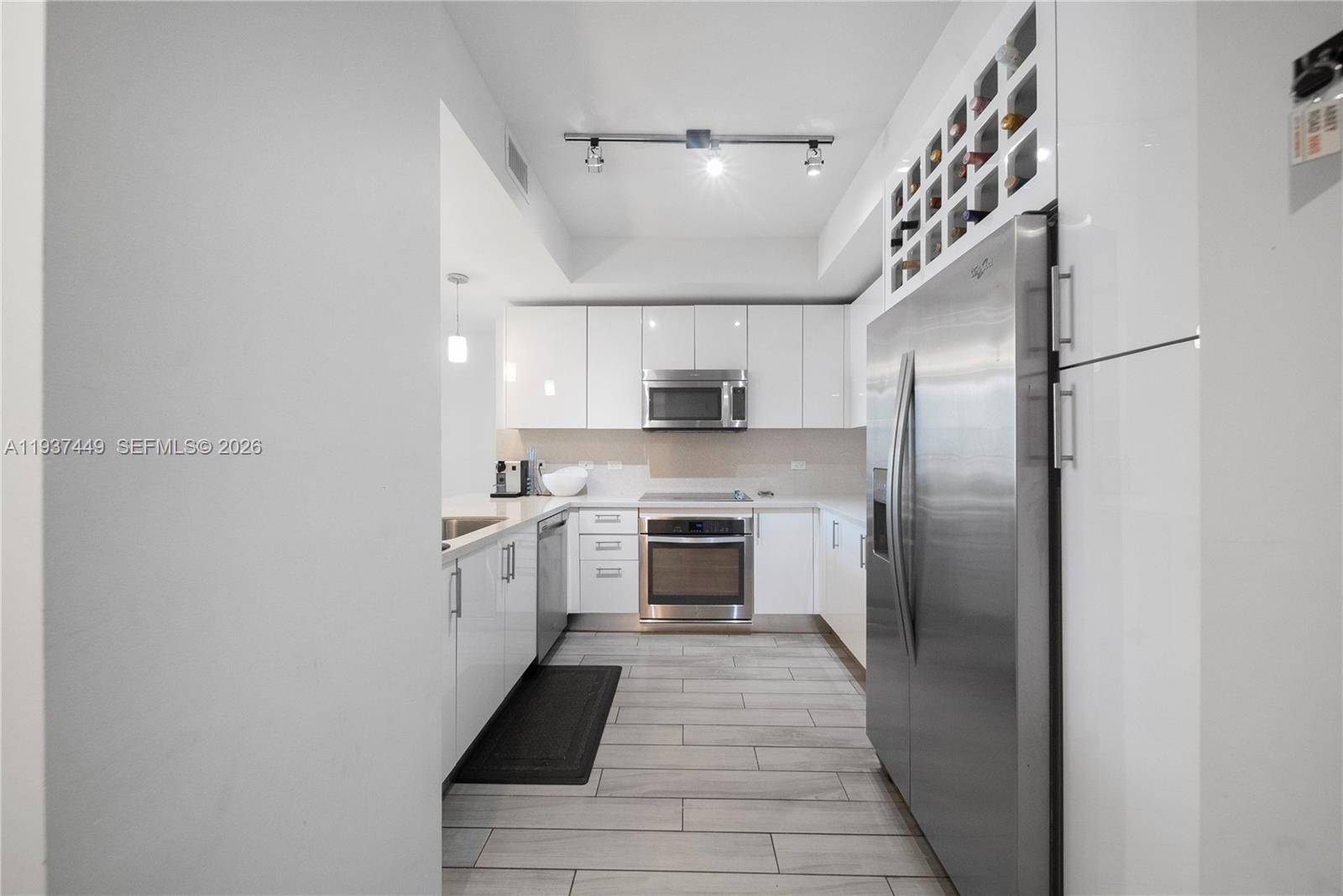 999 Southwest 1st Avenue, Unit 1617 Miami, FL 33130 - Photo 11 of 12 a kitchen with stainless steel appliances a refrigerator sink and stove