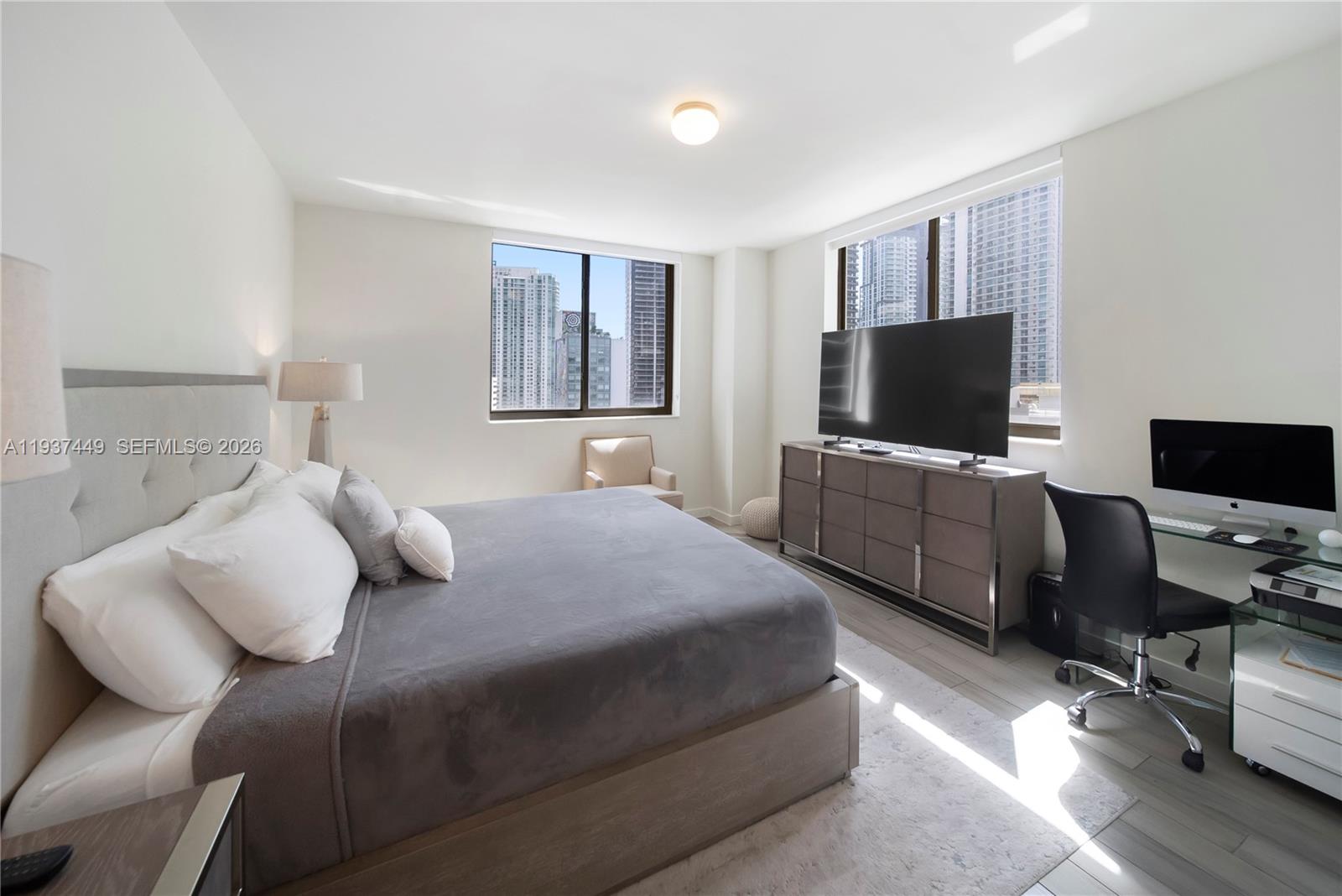 999 Southwest 1st Avenue, Unit 1617 Miami, FL 33130 - Photo 5 of 12 a bedroom with a bed and a flat screen tv