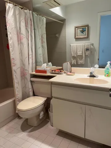 a bathroom with a granite countertop toilet sink and mirror