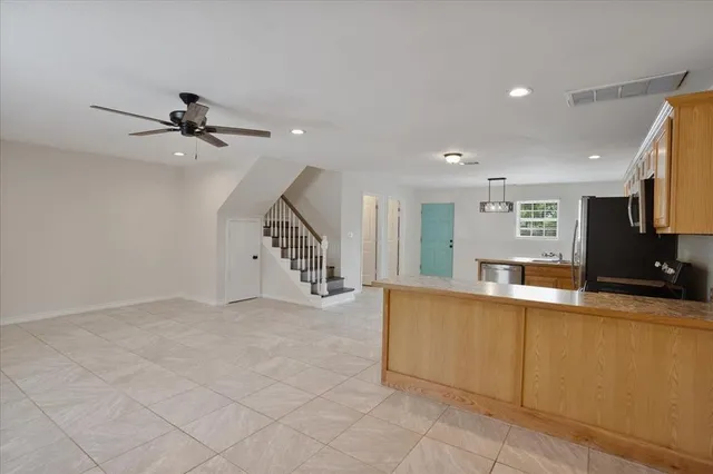 a view of a kitchen with a sink and a chandelier fan
