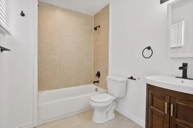 a bathroom with a toilet sink vanity tub and shower